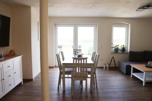 ein Esszimmer und ein Wohnzimmer mit Tisch und Stühlen in der Unterkunft Ferienwohnung Ullrichshof Oberlausitz - Sauna Grillplatz Panoramablick in Malschwitz