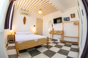 a bedroom with a bed and a checkerboard floor at Bohem Pansiyon in Kuşadası +14 photos