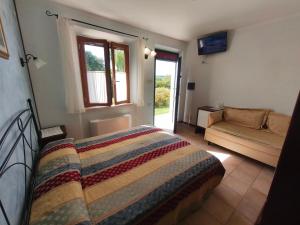 a bedroom with a bed and a couch and a window at B&B La Tenuta del Conte in Fermo