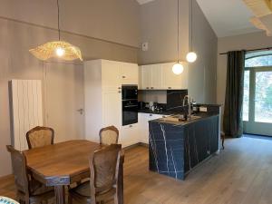 a kitchen and dining room with a wooden table at La Pousterle - Gîte in Salettes +8 photos
