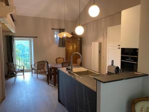 a kitchen with a counter and a dining room at La Pousterle - Gîte in Salettes