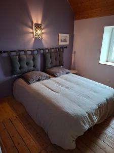 a bedroom with a large bed with a light on the wall at Kazh bihan in Guissény