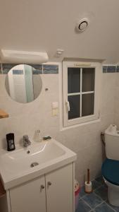 a bathroom with a sink and a toilet and a mirror at Kazh bihan in Guissény