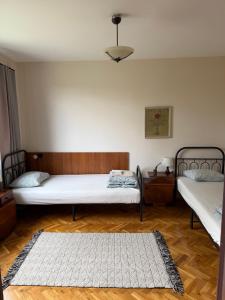 a bedroom with two beds and a rug on the floor at Bankya Guest House - Sofia in Bankya