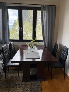 a dining room table with a vase of flowers on it at Bankya Guest House - Sofia in Bankya