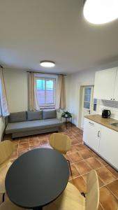 a living room with a table and a kitchen at Dvorek110 in Roudnice nad Labem