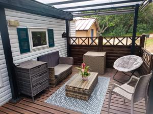 a deck with wicker furniture and a pergola at Escale en Provence in Carqueiranne