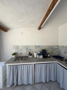 a kitchen with a stove and a counter top at Villa Egidio Terrazza in Sant'Angelo D'Ischia +7 photos