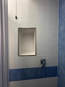 a shower with a mirror and a blue and white tiles at Villa Egidio Terrazza in Sant'Angelo D'Ischia