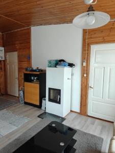 a living room with a fireplace and a white refrigerator at Ranta mökki in Kouvola