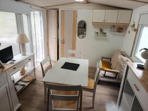 a kitchen and living room with a white table and chairs at Escale en Provence in Carqueiranne