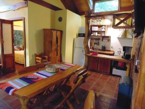 Una cocina con una mesa de madera y un refrigerador. en Alpina Cabañas, en Mar del Plata