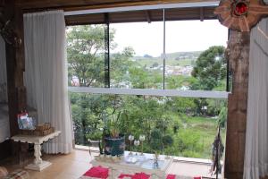 une grande fenêtre avec vue sur un champ dans l'établissement Loft São Joaquim, à São Joaquim