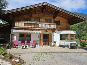 a house with pink chairs in front of it at Ferienwohnungen Inka in Sautens