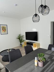 a living room with a table and a tv at NEU Apartment Lotta in Senftenberg