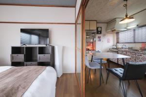 a room with a bed and a table and a kitchen at KEI HOUSE Yamato 201 in Yamato