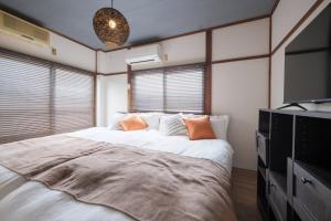 a bedroom with a large bed and a flat screen tv at KEI HOUSE Yamato 201 in Yamato