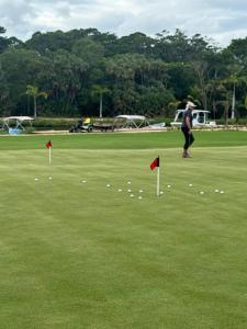 a person standing on a field with golf balls at Tortuga Amarilla 1 in Maya Beach