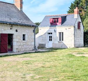 an old stone house with a red window at Cottage de charme en pleine nature avec piscine in Saint-Philbert-du-Peuple