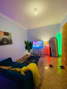 a living room with a blue couch and a mirror at The calm Stay in Nkoanrua