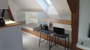 two chairs sitting next to a table in a room at Dvorek110 in Roudnice nad Labem