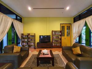 a living room with two couches and a tv at Golden Snapper Guest House in Yan