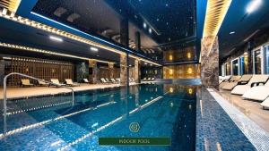 a large swimming pool with chairs and a hotel at Grand Hotel Belushi in Boge
