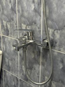 a shower in a bathroom with a hose at Bloom House Përmet in Përmet +26 photos