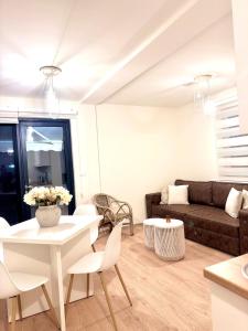 a living room with a white table and a couch at Sand and stone oasis in Ohrid