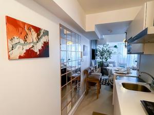 a kitchen and a living room with a table at Sky26 Stays by Paula & Hudson in Pampang