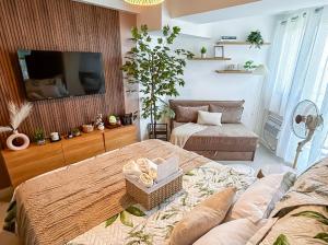a living room with two beds and a flat screen tv at Sky26 Stays by Paula & Hudson in Pampang