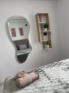 a mirror on a wall with a bed and a chair at Appart laouina in El Aouina Station +5 photos