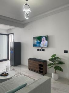 a living room with a couch and a tv on the wall at Appart laouina in El Aouina Station