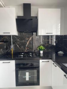 a kitchen with a black stove and white cabinets at Appart laouina in El Aouina Station