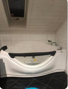 a white bath tub in a bathroom with a faucet at Marits residense in Kongsberg