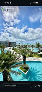 a view of a pool with palm trees in a website at Porto2life Máximo 6 pessoas in Porto De Galinhas