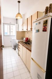 a kitchen with a white refrigerator and a sink at Departamento Mara in Puerto Madryn