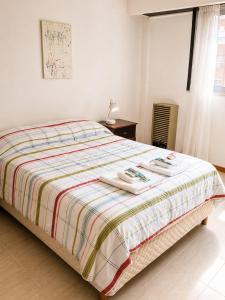a bedroom with a bed with towels on it at Departamento Mara in Puerto Madryn