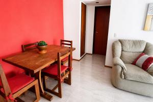 a dining room with a wooden table and a chair at Departamento Mara in Puerto Madryn +12 photos