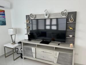 a flat screen tv sitting on top of a entertainment center at Casa Mi Luz - Family-Friendly 3BR Stay with Parking & Self Check-in in San Juan