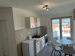 a small kitchen with a table and a table and chairs at E&L Apartments in Kovačina