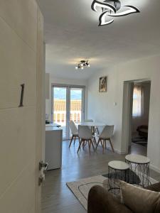 a living room and kitchen with a table and chairs at E&L Apartments in Kovačina +5 photos