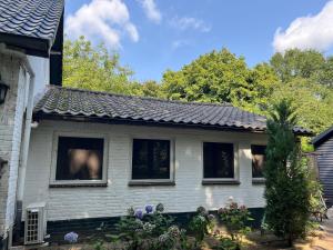 a white house with windows and a roof at B&B Itterhoeve in Neeritter