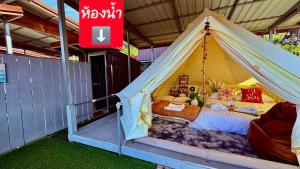 a tent with a bed in it with a sign at มองวิวภูชี้ฟ้า รีสอร์ท in Ban Seng Choi