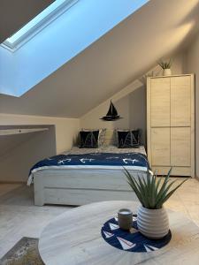 a bedroom with a large bed and a table at Poddasze Na Mazurach in Pisz