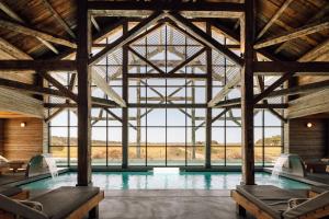 an indoor pool in a building with large windows at Quinta Da Comporta - Wellness Boutique Resort in Comporta