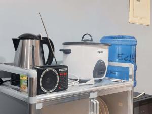 a kitchen counter with a coffee maker and a microwave at Pineda Villa in Puerto Princesa City