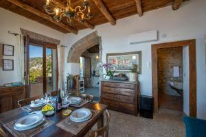 a dining room with a wooden table with chairs and a chandelier at Mareluna Cottage in Conca dei Marini