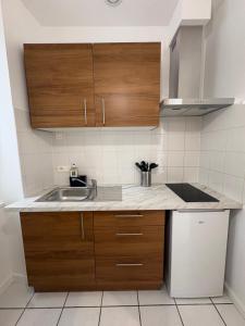 a kitchen with wooden cabinets and a sink at Studio T1 in Dax