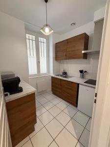 a kitchen with wooden cabinets and a tiled floor at Studio T1 in Dax